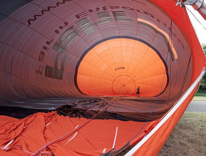 Bayern 08 - 2016_KA70780-1 Kopie.jpg - Und gleich ein Highlight. Direkt vor unserem Wohnmobil bauen fleißige Männer einen Heißluftballon auf.